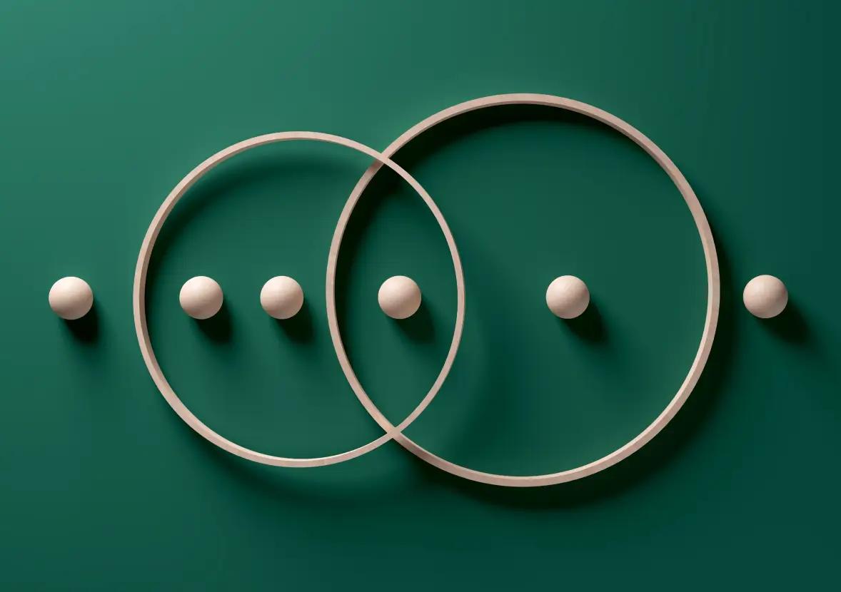 Two circles laying on a greed background with small balls organized inside of the two circles.