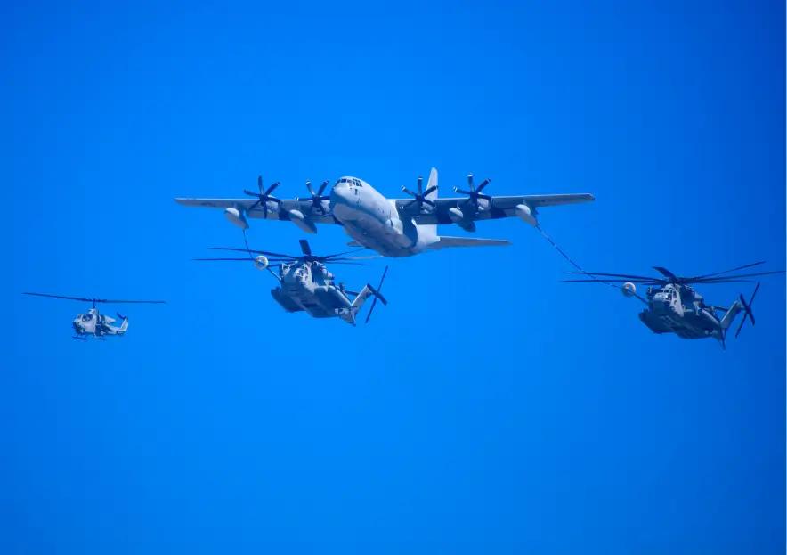 Multiple US Air Force planes and helicopters flying in formation.